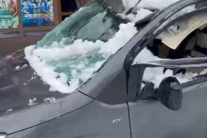 Park halindeki aracın üzerine çatıdan kar kütlesi düştü